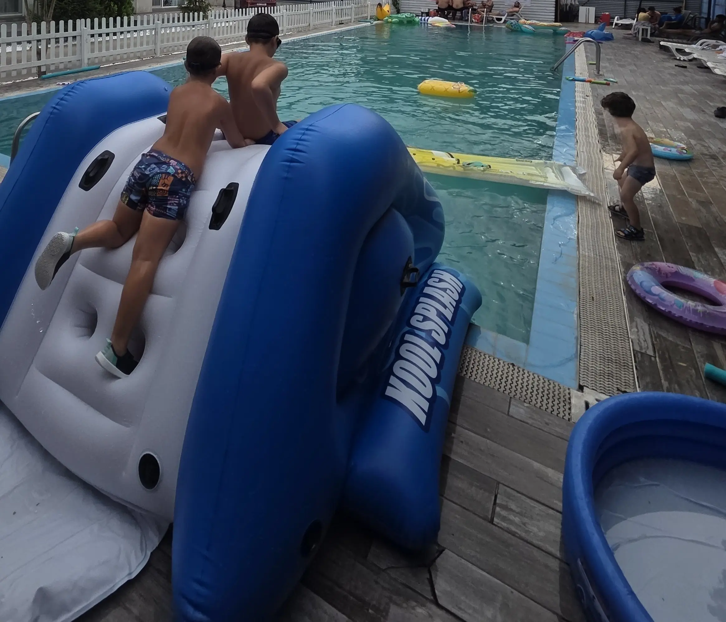Copii jucându-se pe tobogan gonflabil lângă piscină, petrecere de vară Ilfov